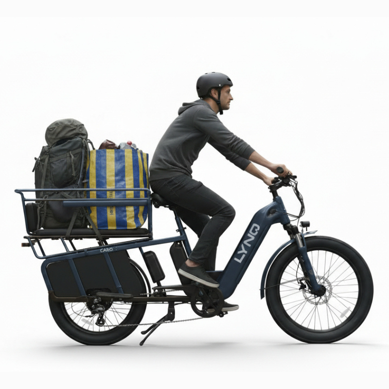 A rider hauls gear on the LYNQ Relay cargo electric bike with loaded rear platform.